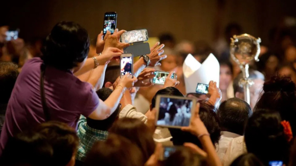 Feligreses capturando momentos con sus teléfonos móviles, un reflejo de la influencia digital en el primer Jubileo para influencers católicos